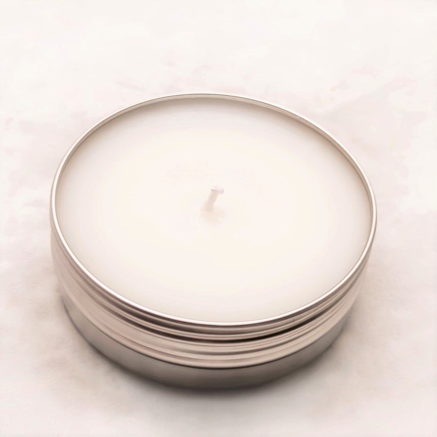 image of 2 oz travel or sample size candle tin with the lid off on a white background