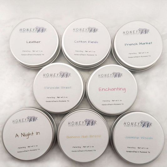 image of 2 oz travel or sample size candles. 8 candles pictured: Leather, Cotton Fields, French Market, Fireside Treat, Enchanting, A Night in, Banana Nut Bread, and Jasmine Woods