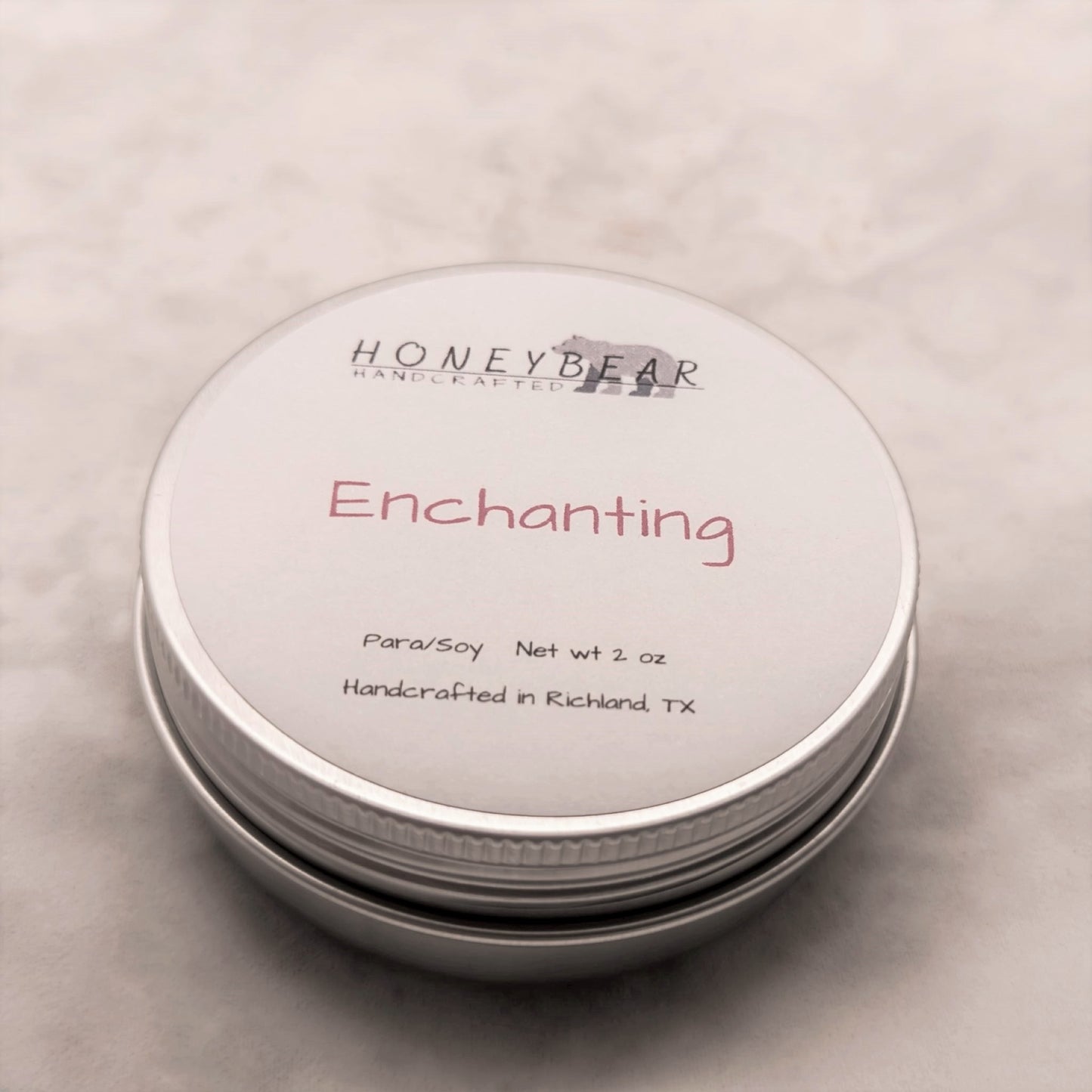 image of 2 oz travel or sample size candle labeled Enchanting on a white background